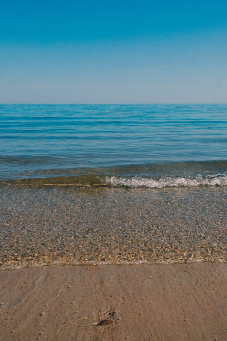 Clear blue water from the sea hitting the beach