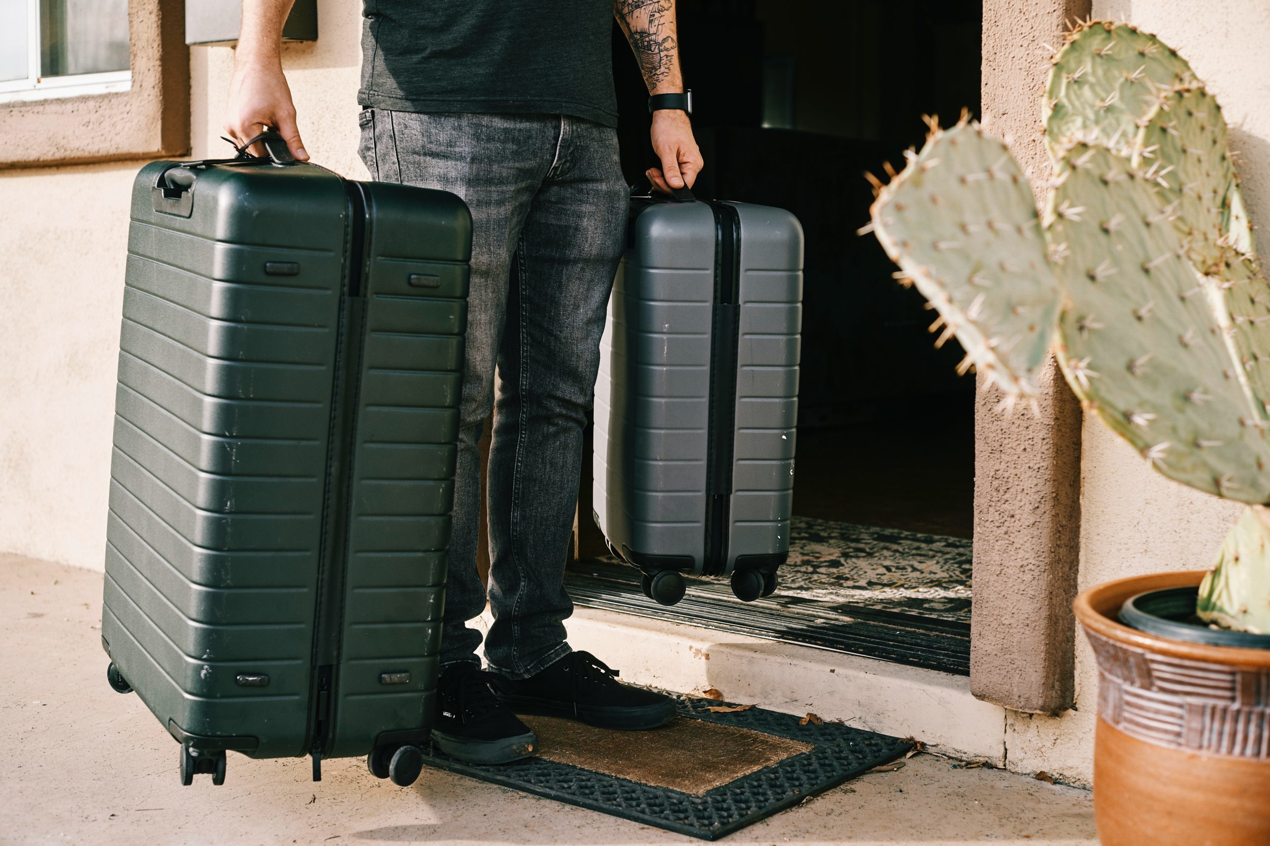A man holding two large suitcases