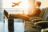 Man relaxing at an airport with legs on a suitcase while an airplane departs