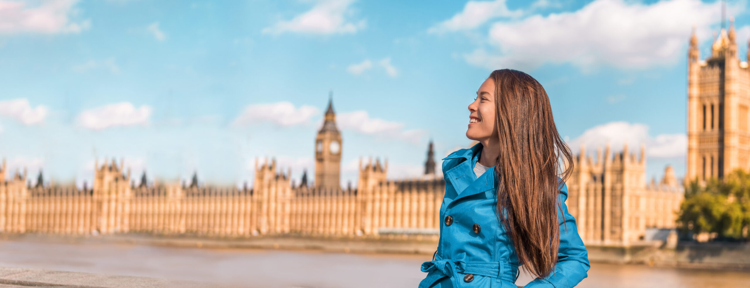 Girl in a blue coat with Big Ben & Houses of Parliament in the background